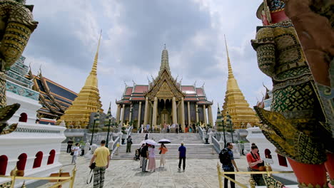 Tourists-going-through-the-main-entrance-of-the-Grand-Palace,-more-popularly-known-as-Wat-Phra-Kaew-in-Bangkok,-Thailand