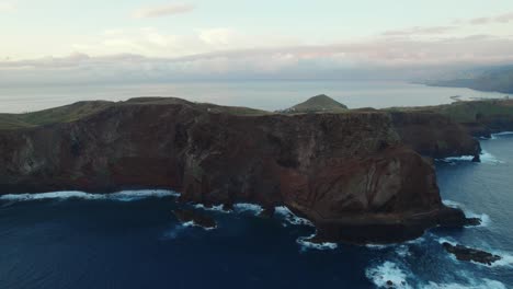 Drones-Volando-Sobre-El-Mar-Junto-A-La-Costa-En-Ponta-Do-Rosto,-Madeira,-Mientras-Que-El-Paisaje-Es-Visible-Al-Fondo-Con-Olas-Y-Montañas-En-Madeira