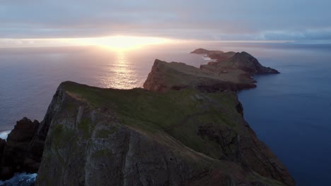 Serene-Sunset-over-Rugged-Coastal-Landscape-during-sunrise-with-a-drone-at-Ponta-Do-Rosto,-Madeira