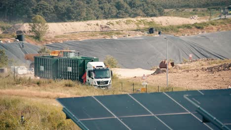 Un-Semirremolque-Circula-Entre-Paneles-Solares-Y-Un-Vertedero.