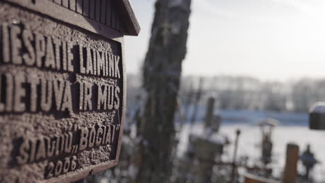 Sculpture-sign-on-the-Hill-of-Crosses,-Lithuania,-saying:-Lord,-bless-Lithuania-and-us