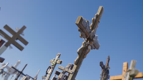 Antiguas-Cruces-Religiosas-Con-Rosarios-En-Un-ángulo-Holandés-Bajo-Un-Cielo-Azul,-Filmada-Cinematográfica-En-Cámara-Lenta