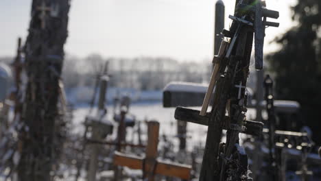 Alte-Religiöse-Kreuze-Mit-Rosenkränzen-Im-Gegenlicht-Mit-Sonnenstrahlen,-Unter-Blauem-Himmel,-Filmische-Aufnahme-In-Zeitlupe