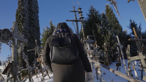 Pilgrim-woman-wearing-coats-walks-on-the-Hill-of-Crosses-in-Lithuania