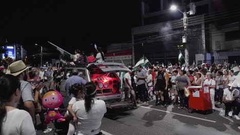 Music-blasts,-flags-wave-at-street-rally-in-Bolivian-city,-Santa-Cruz