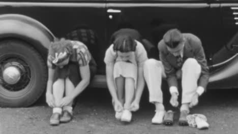 Man-and-Two-Women-Sitting-in-a-Classic-Car-Changed-Shoes-in-New-York-City-1930s