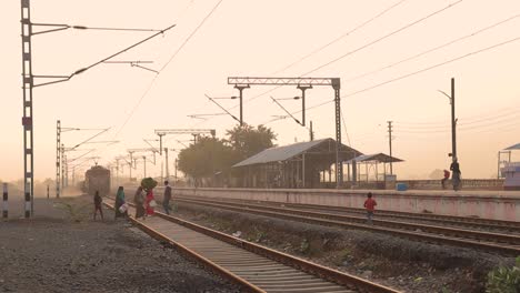 Foto-Fija-De-Personas-Cruzando-Vías-De-Tren-En-Una-Estación-De-Tren-En-La-India-Durante-La-Puesta-De-Sol.