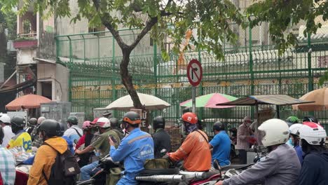 Motorcyclists-waiting-at-the-traffic-junction-in-Ho-Chi-Minh-City,-Vietnam