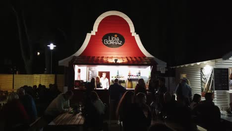 La-Gente-Disfruta-De-Los-Vinos-Locales-Frente-A-La-Bodega-Lídia-Por-La-Noche-Durante-Las-Tradicionales-Semanas-Del-Vino-Batonfuredi-En-Hungría.