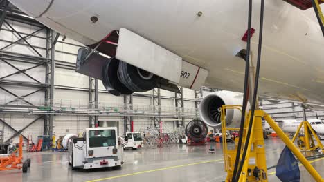 Un-Boeing-787-Dreamliner-Está-Sobre-Gatos-De-Mantenimiento-Para-Hacer-Girar-El-Tren-De-Aterrizaje-En-Un-Hangar-De-Aviones