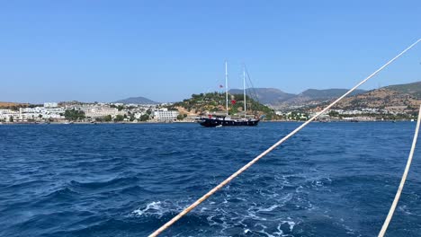 Vistas-A-La-Ciudad-Y-A-La-Montaña-Desde-Un-Gran-Velero-En-Bodrum,-Turquía,-Divertidas-Vacaciones-De-Verano,-Barco-En-Movimiento,-Destino-De-Vacaciones-De-Lujo,-Día-Soleado-En-El-Mar-Con-Cielo-Azul,-Toma-De-4k