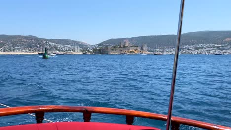 Popa-De-Madera-En-Un-Gran-Velero-En-Bodrum-Turquía-Con-Vistas-A-La-Ciudad,-Divertidas-Vacaciones-De-Verano,-La-Parte-Trasera-De-Un-Barco-En-Movimiento,-Destino-De-Vacaciones-De-Lujo,-Día-Soleado-En-El-Mar-Con-Cielo-Azul,-Toma-De-4k