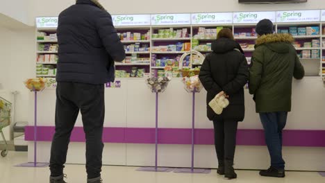 Farmacia.-Gente-Esperando-En-El-Mostrador-De-La-Farmacia.