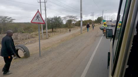 Rider-On-Motorcycle-With-Heavy-Load-Overtake-On-A-Car-Driving-In-The-Highway-In-Narok,-Kenya