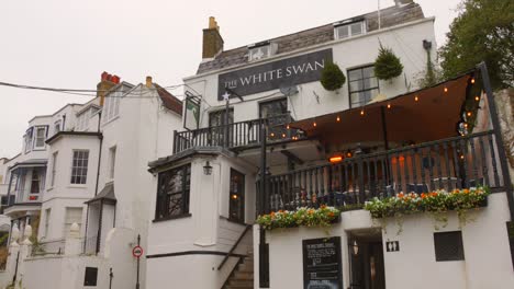 Tilt-down-shot-of-The-White-Swan-pub-and-restaurant-in-Twickenham,-London-suburbs,-UK-on-a-cloudy-day