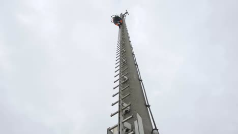 Worker-ascending-a-towering-ladder-into-a-cloudy-sky,-concept-of-challenge-and-work