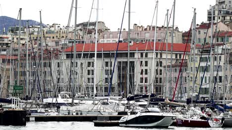 Bootshafen-Und-Gebäude-Mit-Menschen,-Die-Sich-Um-Yachten-Kümmern,-Handheld-Nahaufnahme-Vom-Boot-Aus