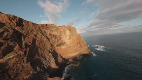 FPV-drone-cruising-on-the-edge-of-the-ridgeline-at-Ponta-do-Rosto-beach-during-sunrise