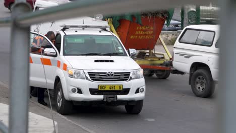 Pathology-technician-by-branded-emergency-van-with-flashing-lights-attending-crime-scene