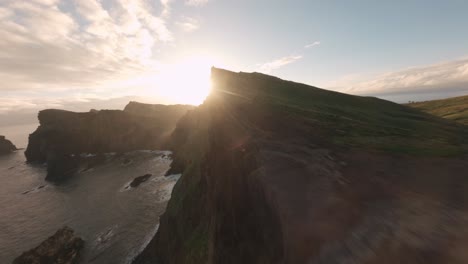 FPV-drone-cruising-on-the-edge-of-the-ridgeline-at-Ponta-do-Rosto-beach-during-sunrise