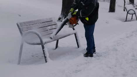 Hombre-Quitando-Nieve-Del-Banco-De-Un-Parque-Público-Con-Un-Soplador-De-Hojas