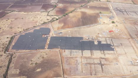 Aerial-drone-view-showing-sun-rays-shining-on-solar-panels-as-they-fall-into-the-camera