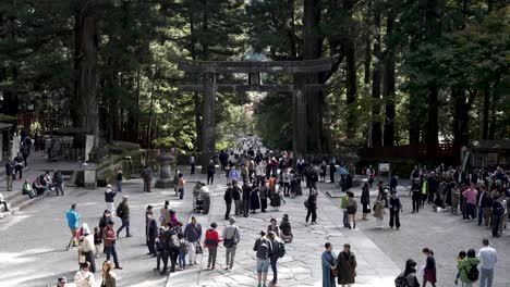 Slow-motion-of-people-in-front-of-the-Ishi-tori'i-at-Nikko,-Japan,-serving-as-a-cultural-and-historical-emblem