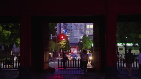 Static-background-shot-of-Tokyo-as-people-and-traffic-pass-by-temple