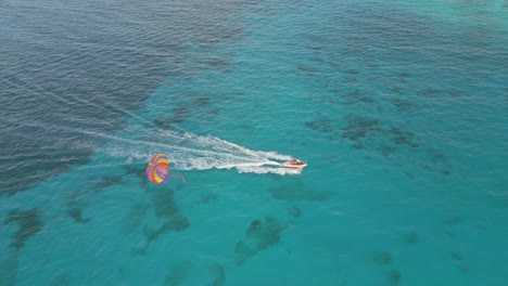 Vista-Aérea-De-Turistas-Haciendo-Parasailing-Sobre-Las-Aguas-Turquesas-Del-Caribe.