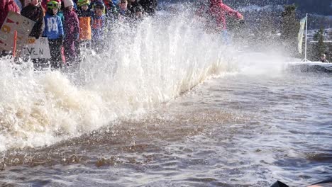 Man-skis-down-a-hill-and-across-a-pool-of-ice-water-at-a-community-celebration