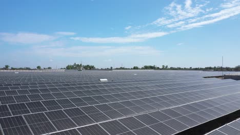 Vista-Aérea-De-Drones-Cámara-De-Drones-Moviéndose-Hacia-Adelante-Y-Hacia-Atrás-Mostrando-Una-Gran-Planta-De-Energía-Solar-En-Un-Campo