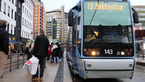 Electric-tram-pulls-into-Central-Station-in-Oslo,-Norway-on-a-wet,-rainy,-winter-day