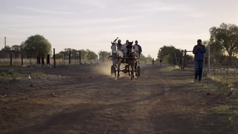 Conductor-Y-Pasajeros,-Carties,-Montar-A-Caballo-Y-Carro-De-Chatarra-Al-Atardecer-Por-Un-Camino-De-Tierra-Rural-En-El-Municipio-De-Sudáfrica