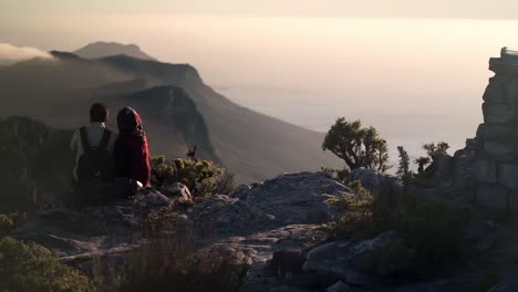 2-young-lovers-lookout-on-a-beautiful-mountain-top-view-as-the-sunsets-and-the-clouds-roll-in