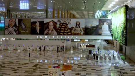 Riesige-Halle,-Die-Am-Frühen-Morgen-Zur-Einwanderungskontrolle-Am-Changi-Flughafen-Führt,-Mit-Sehr-Wenigen-Menschen