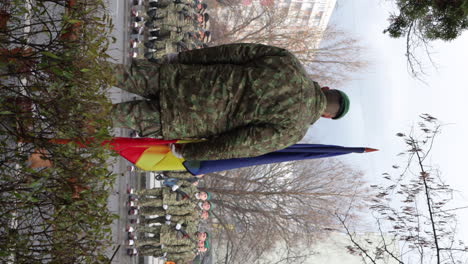 Vertikal---Soldat-Hält-Rumänische-Flagge-Vor-Truppen-In-Miercurea-Ciuc