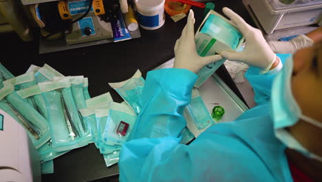 Over-shoulder-static-shot-of-dental-nurses-preparing-clean-tools-for-storage