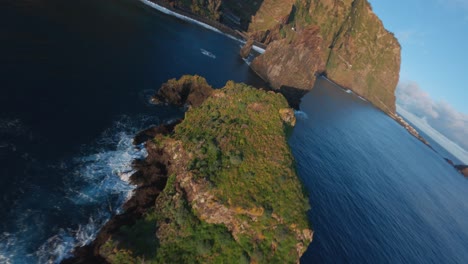 FPV-Drohne-Fliegt-Bei-Sonnenaufgang-über-Dem-Blauen-Ozean-Zwischen-Felsformationen-An-Der-Küste-Von-Ribeira-Da-Janela,-Madeira