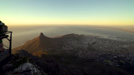 Eine-Touristenfamilie-Posiert-Von-Einer-Aussichtsplattform-Auf-Dem-Tafelberg-Aus-Für-Ein-Foto,-Während-Die-Kamera-Hinüberschwenkt-Und-Die-Wunderschöne-Aussicht-Auf-Kapstadt-Offenbart