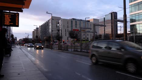 Commuters-wait-for-their-bus-in-the-Barcode-area-of-Oslo,-Norway-on-a-winter-evening-at-dusk