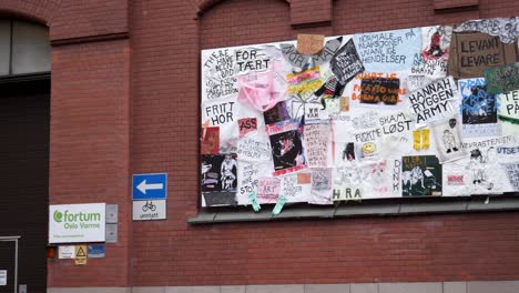 Anuncios-Escritos-A-Mano-Y-Graffiti-En-El-Costado-De-Un-Edificio-De-Ladrillo-Rojo-En-Oslo,-Noruega