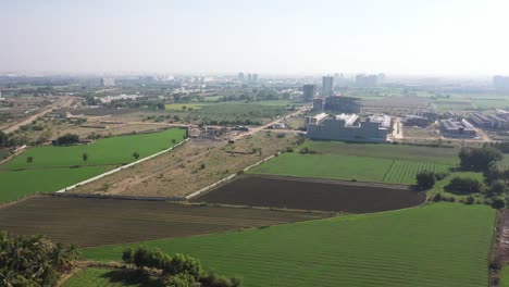 Vista-Aérea-De-Drones-Cámara-De-Drones-Avanzando-Mostrando-Casas-Y-Grandes-Campos