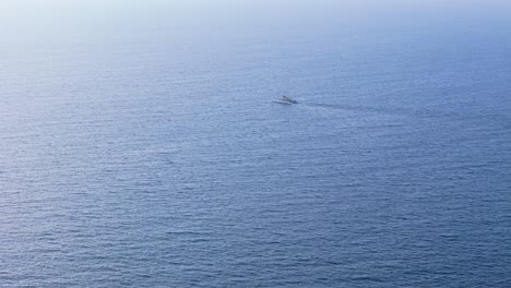 Catamaran-floats-in-calm-empty-serene-ocean-water-with-ripples-as-soft-light-spreads