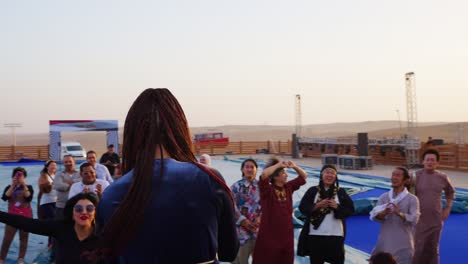 A-singer-performs-on-a-stage-in-front-of-audience-overlooking-pyramids,-Giza-in-Egypt-Arc-shot