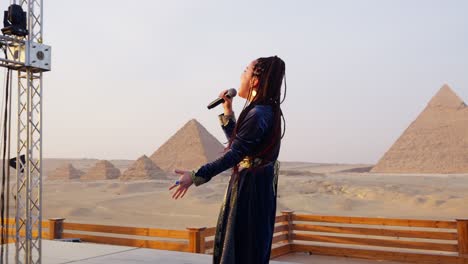 Un-Cantante-Actúa-En-Un-Escenario-Con-Vistas-A-Las-Pirámides,-Giza-En-Egipto-Primer-Plano