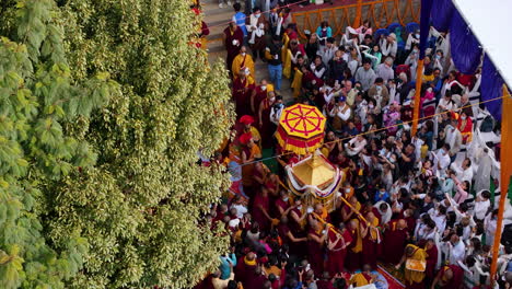 Buddhist-religion-religious-ritual-ceremony-at-Namobuddha-Dhulikhel-Nepal,-drone-shot-captures-the-essence-of-beauty-in-tradition,-people-carrying-chariot,-lamas-and-holy-activities-4K