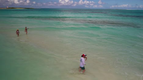 Pareja-Joven-Romántica-Caminando-Juntos-En-Un-Banco-De-Arena-Inundado-Cayo-De-Agua,-Luna-De-Miel