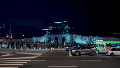 Festival-De-Luz-De-Gwanghwamun-De-Seúl:-Proyección-De-Luces-Artísticas-En-La-Puerta-De-Gwanghwamun-Por-La-Noche,-Gente-Y-Lapso-De-Tiempo-De-Tráfico