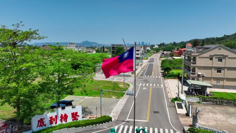 Toma-Aérea-En-órbita-De-Ondeando-La-Bandera-Taiwanesa-En-La-Isla-Kinmen-Durante-El-Día-Soleado-Con-Cielo-Azul