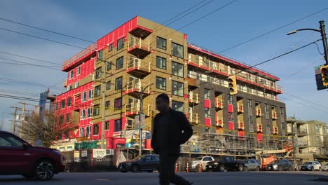 Modernes-Apartmentgebäude-Entlang-Der-Straße-Mit-Verkehr-Im-Vordergrund